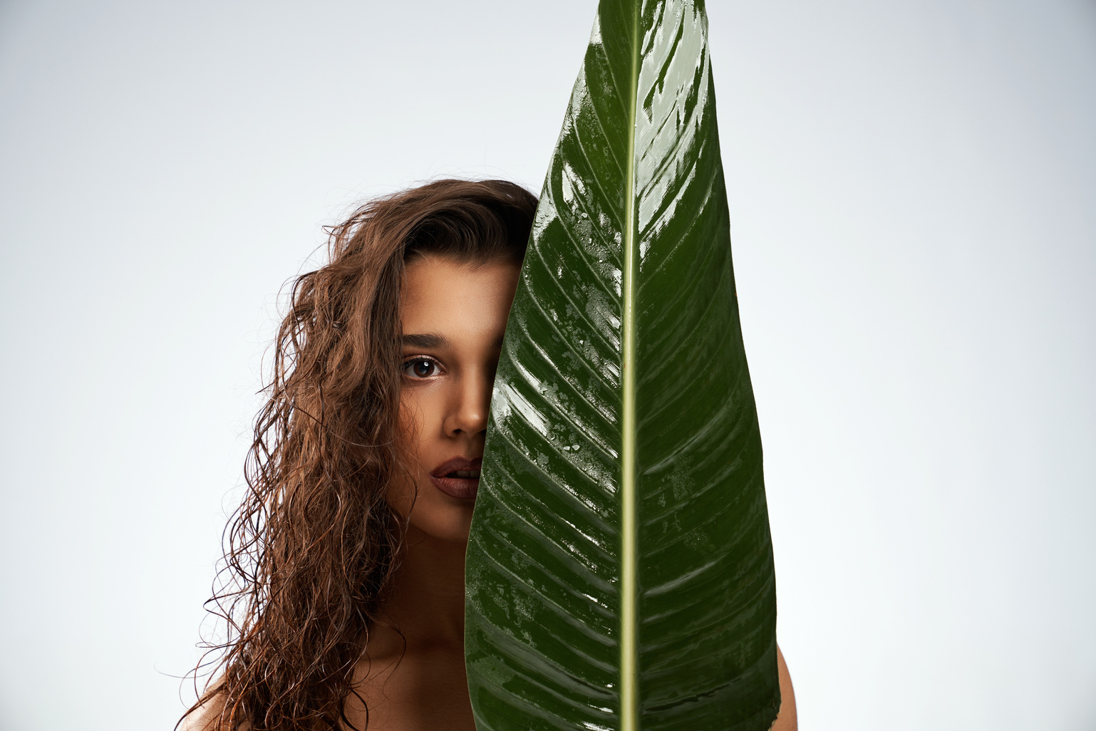 Portrait of Woman Partially behind a Leaf 